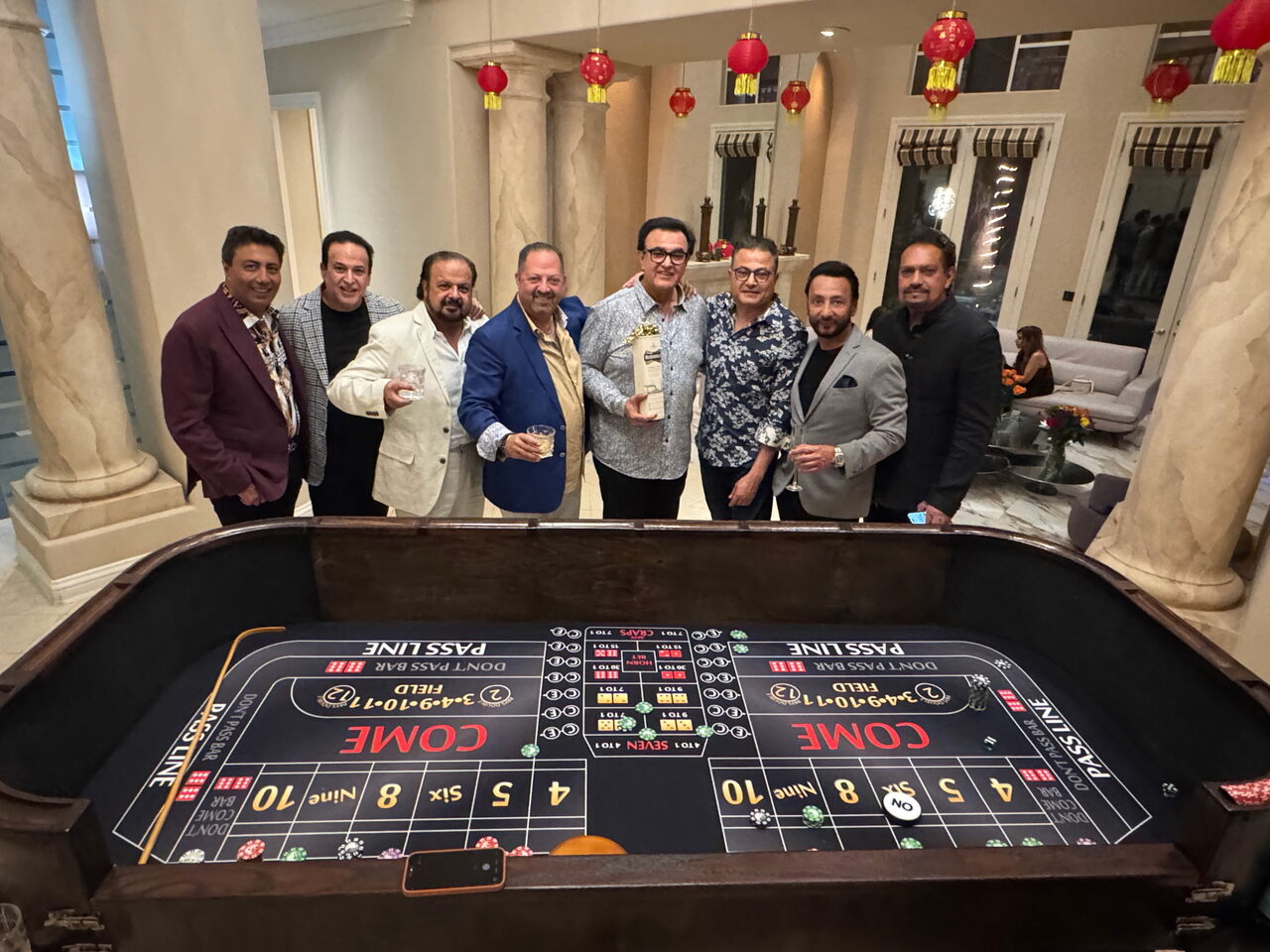 Friends celebrating around a craps table at a Folsom estate casino party