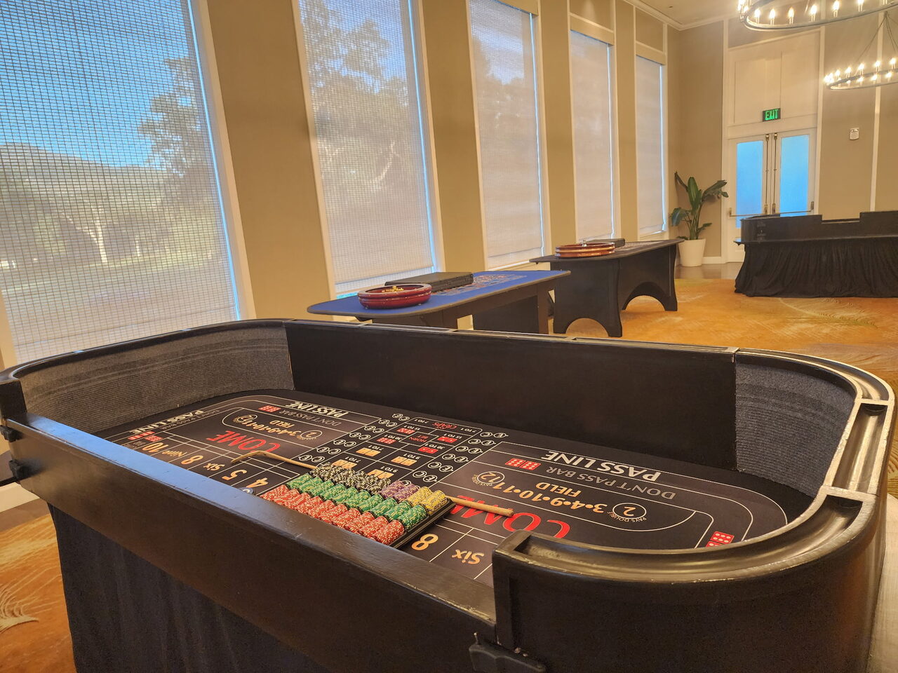 Craps table by floor-to-ceiling windows with a garden view at a Sacramento venue